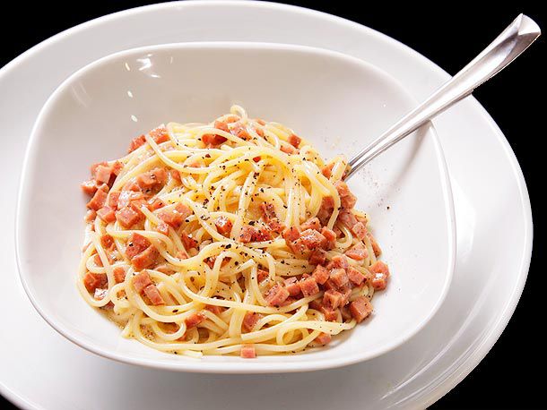 Spamghetti carbonara served in a squarish white bowl.