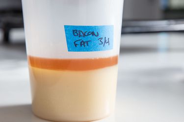 A container of bacon fat, labeled with a date.