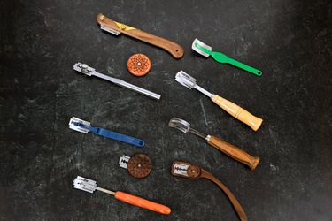 A collection of ten bread lames, which are handles and rods that support a razor blade for scoring bread dough.