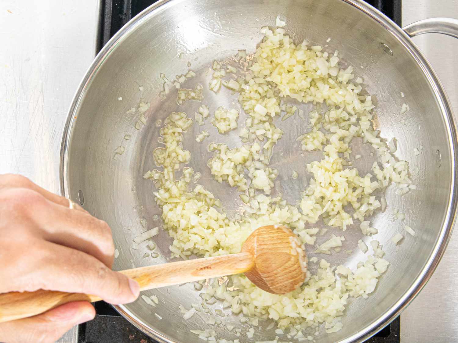 Overhead view of cooking onions in pan