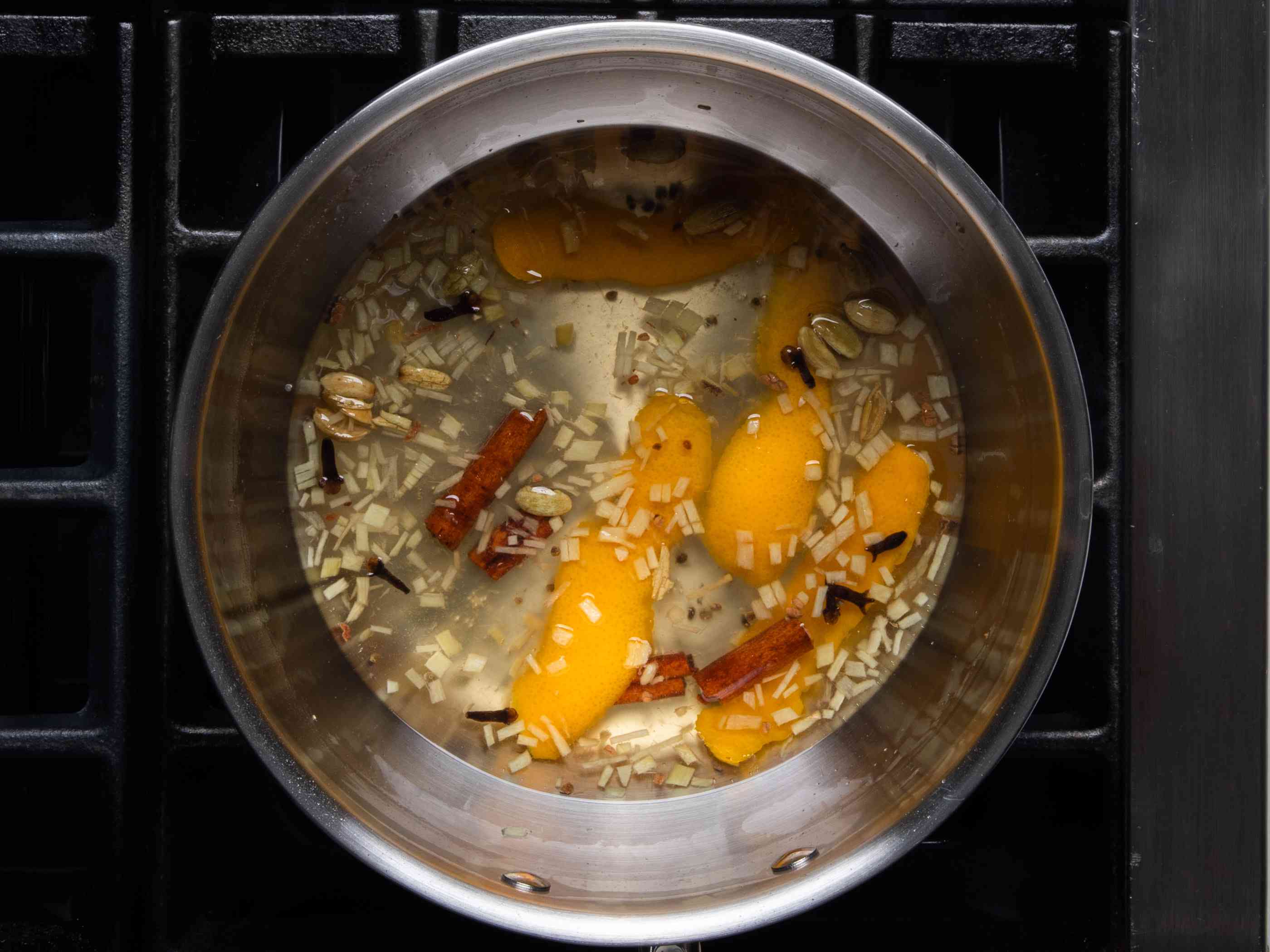 香料、橘皮和姜丁放在盛有淡色糖浆的炖锅里。