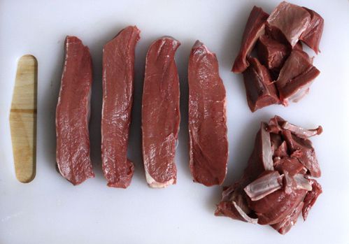 生牛肉心切条，切成方块，放在白色砧板上。