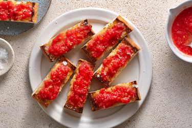 Pan Con Tomate (Spanish-Style Grilled Bread With Tomato) on a white ceramic plate.