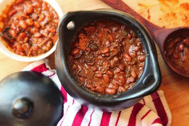 Overhead view of a black la chamba clay pot full of barbecue beans.