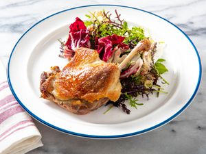 A plate of crispy duck and bitter greens.