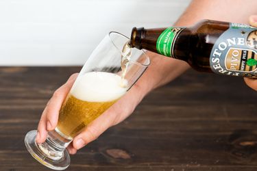 Pouring a beer in a glass.