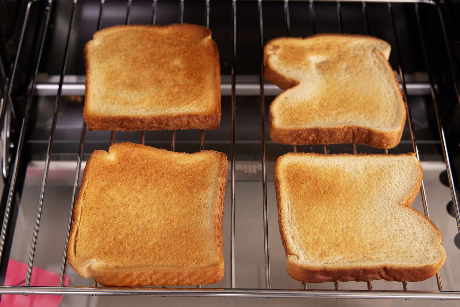 Four slices of toast on an air fryer toaster oven's rack