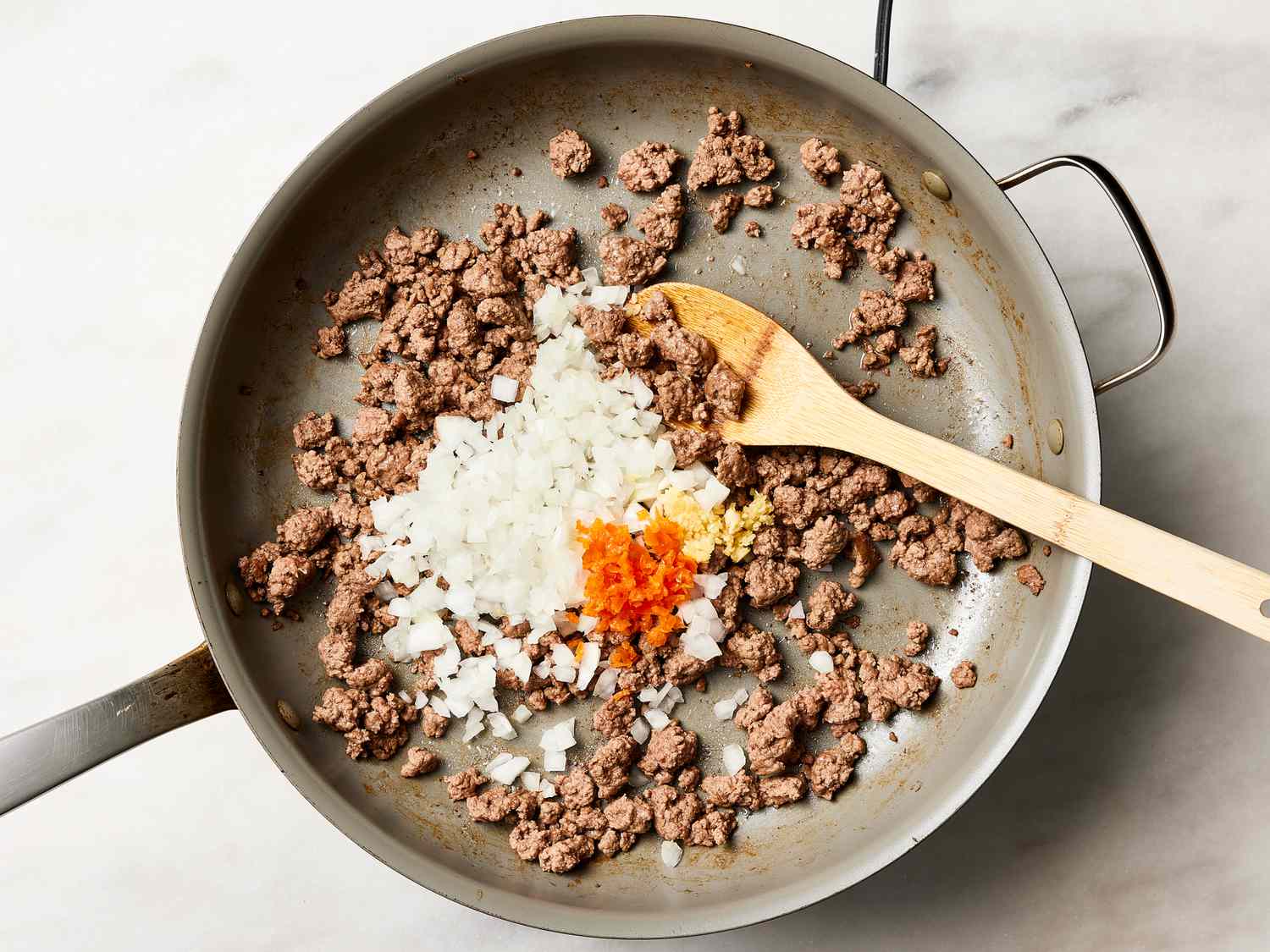 Overhead viwe of meat, onion and spices in a pan