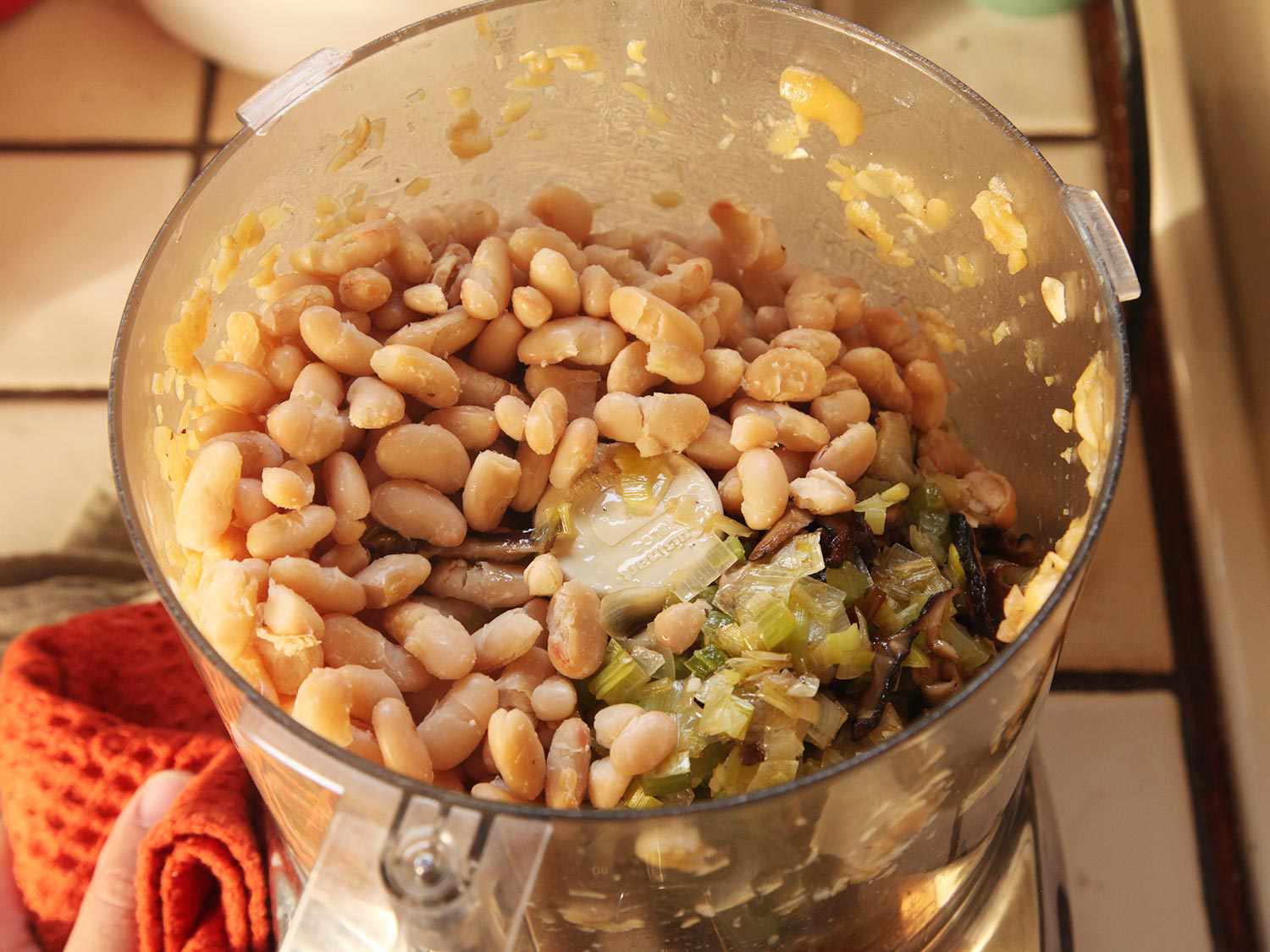 在一碗食品加工机中放入意大利豆和香菇混合物。