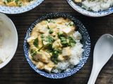 Overhead view of slippery eggs with tofu and peas in a blue patterned bowl