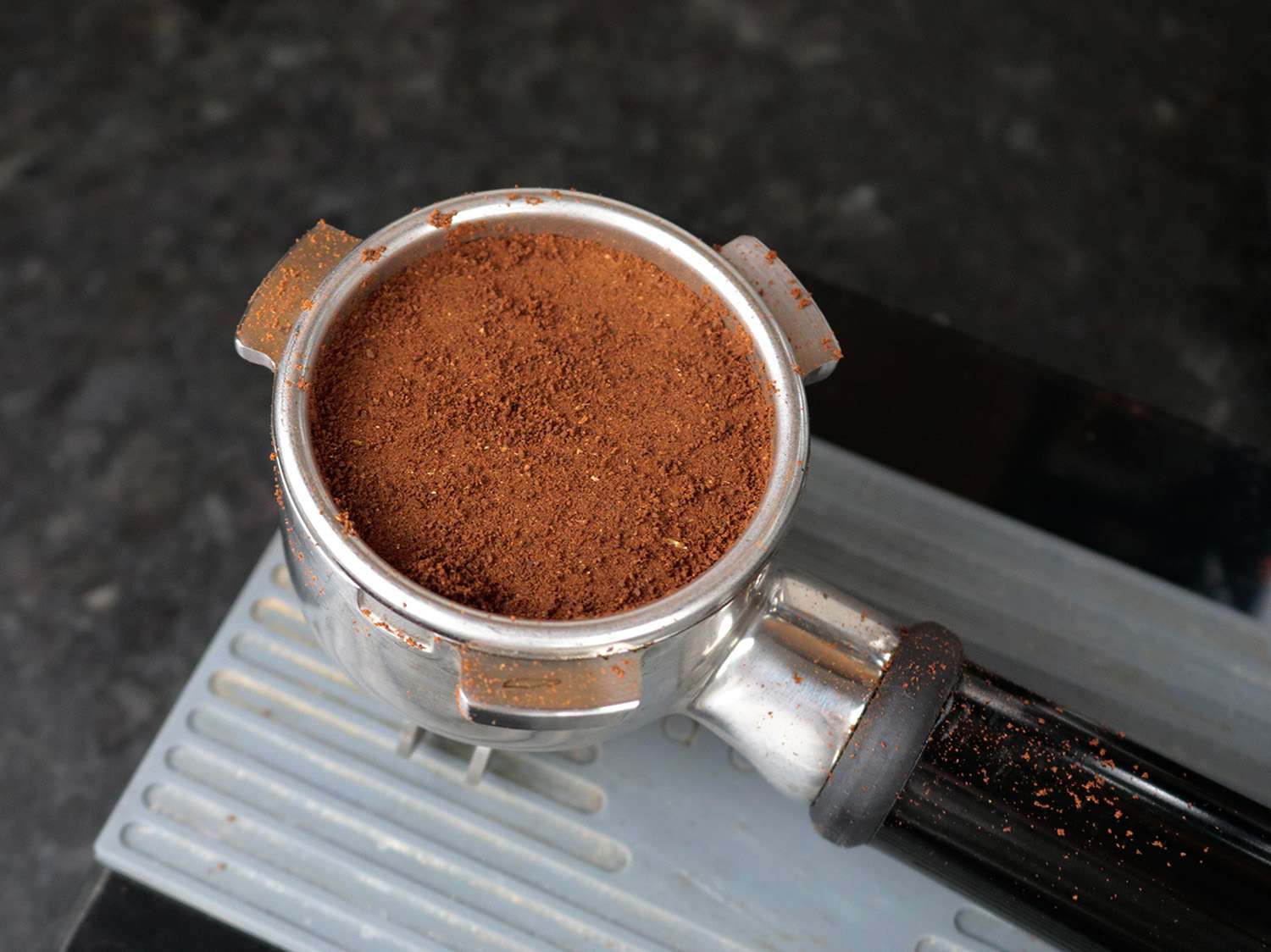 a tamped puck of coffee in a portafilter basket