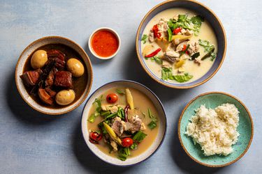 Overhead view of three thai soups with rice and dipping sauce