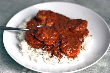 A plate of shrimp tikka masala over rice.