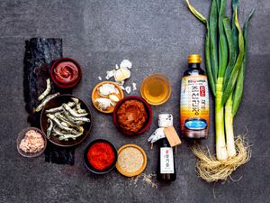 Overhead view of Korean pantry ingredients arranged on a dark gray surface.