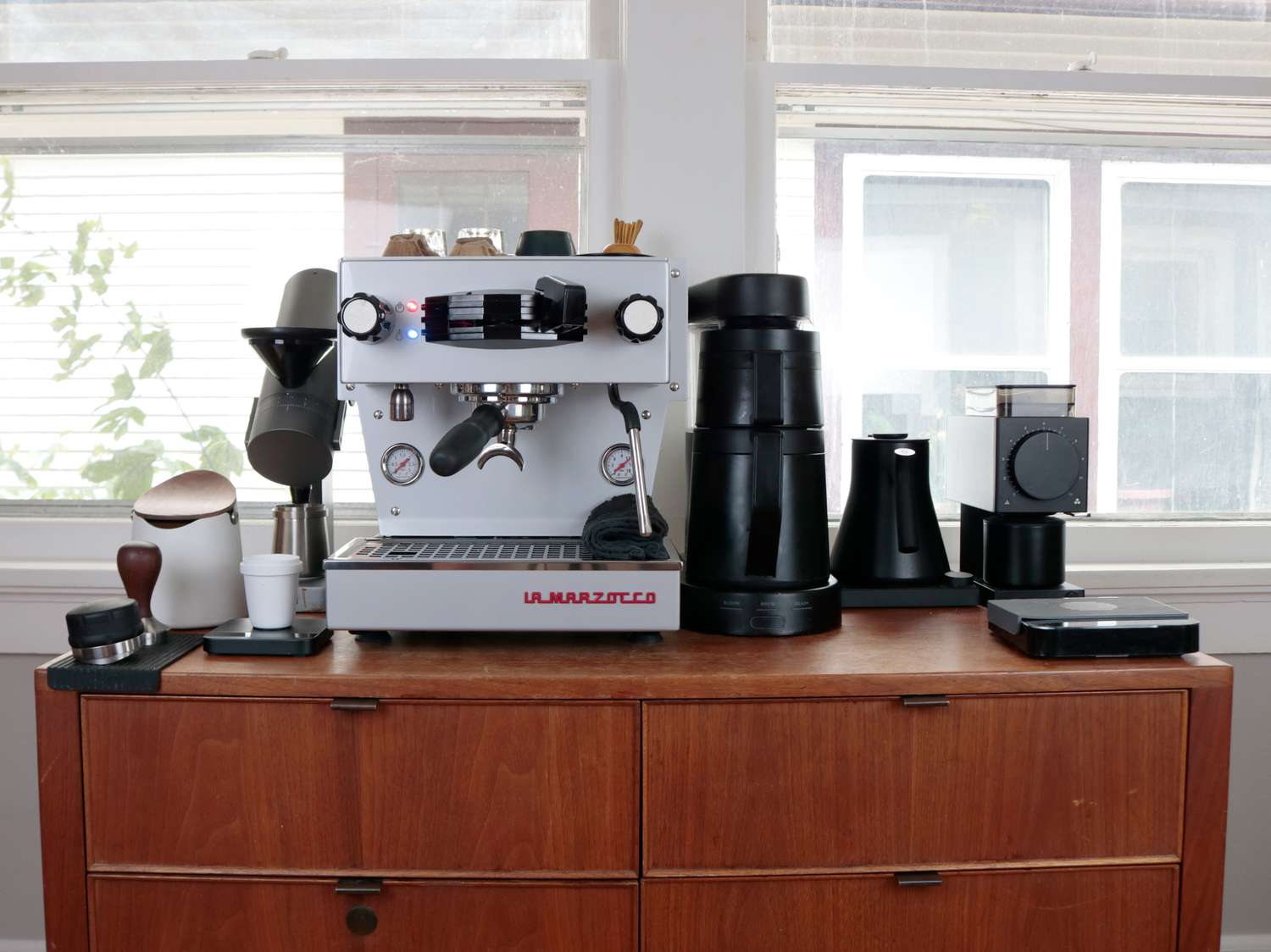 a wooden console table with a full coffee bar on top of it