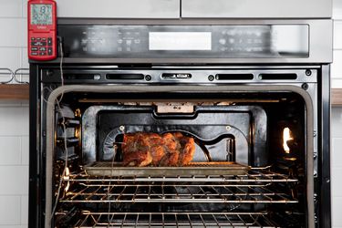 烤炉内的烤鸡，烤炉外有一个探针温度计板