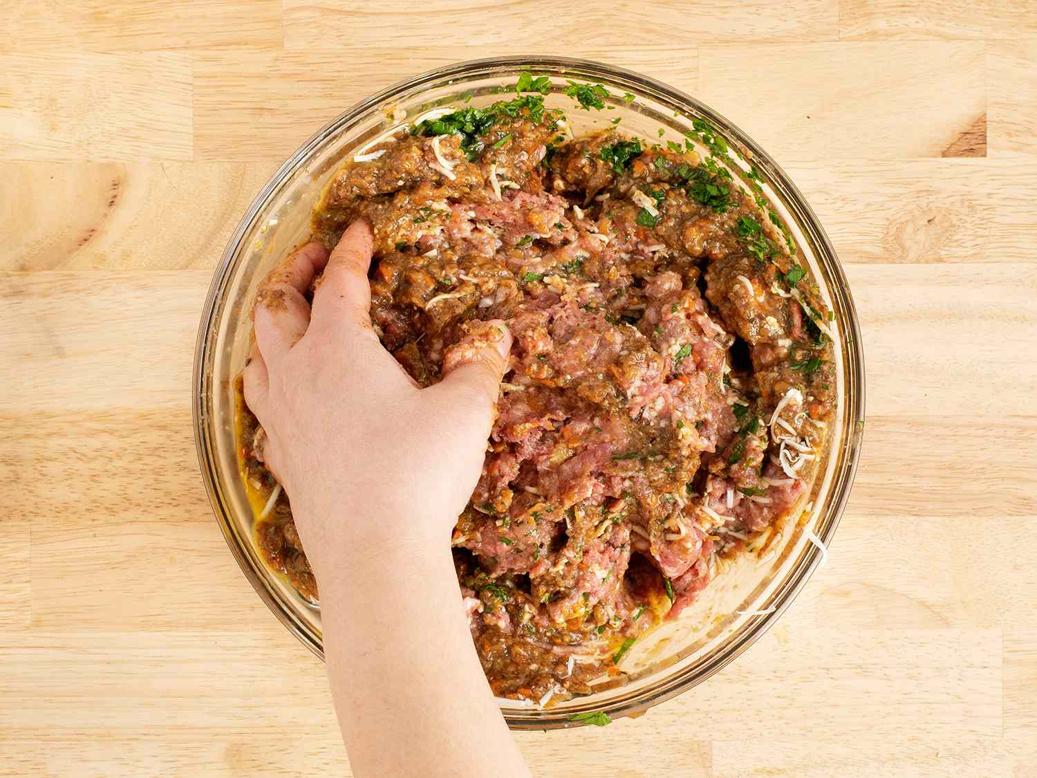 Hand mixing meatloaf mixture in a bowl