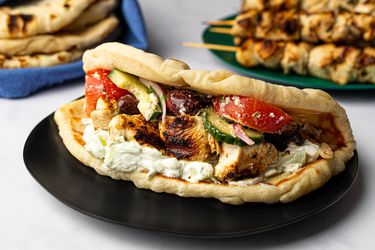 Skewers served with salad, pita, and tzatziki sauce