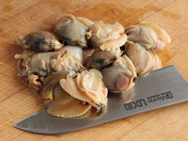整只煮熟的蛤蜊去壳，准备剁碎。