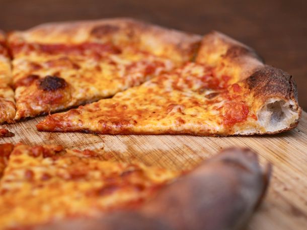 在砧板上切成片的自制纽约式芝士披萨。
