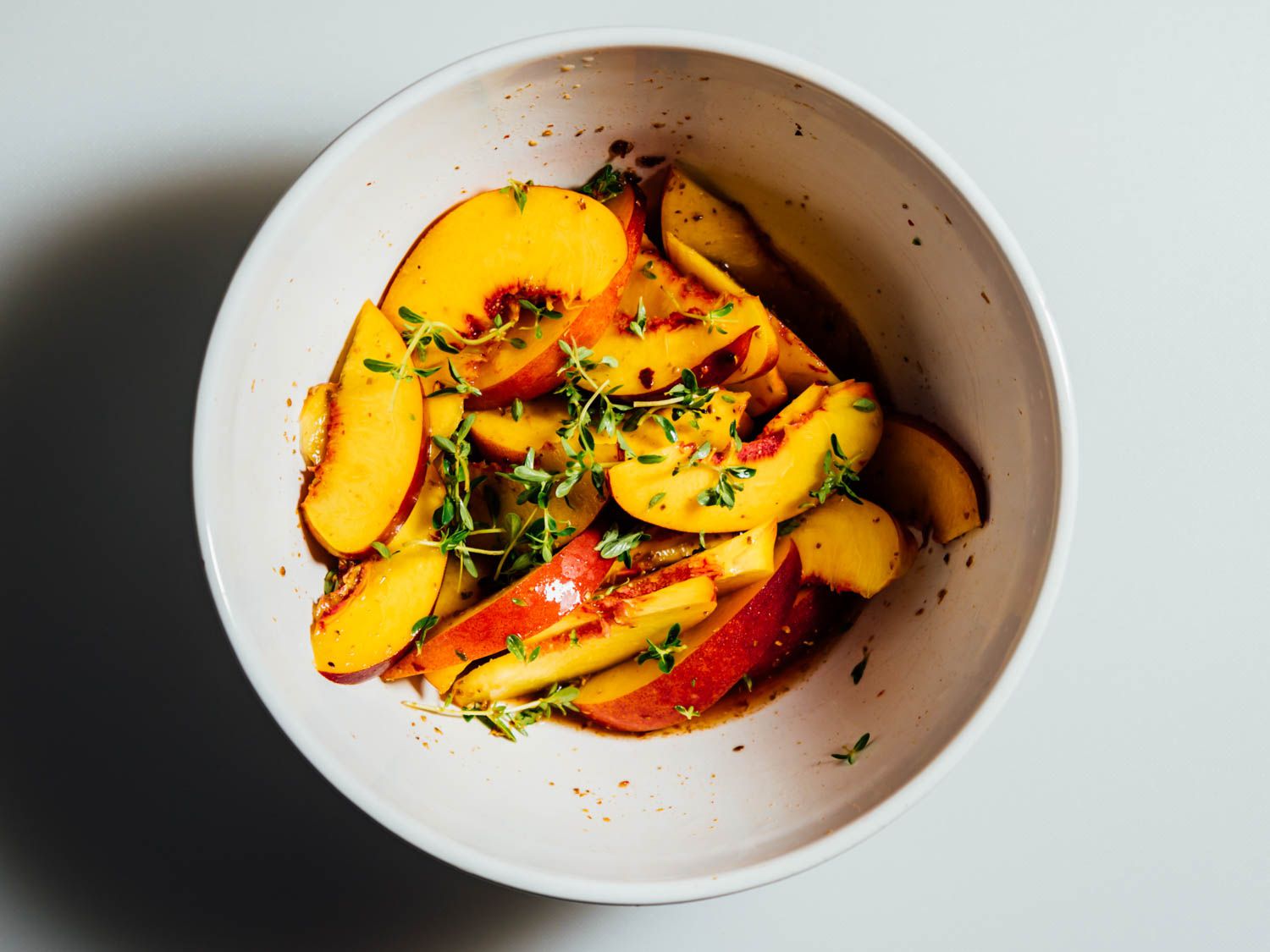 Nectarine segments are pickled in a bowl.