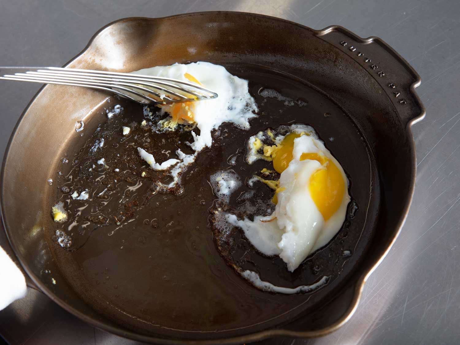 几乎每一个煎锅里的鸡蛋都被卡住了，比如图中所示的Butter Pat煎锅，当抹刀试图抬起它们时，鸡蛋会被扯破。