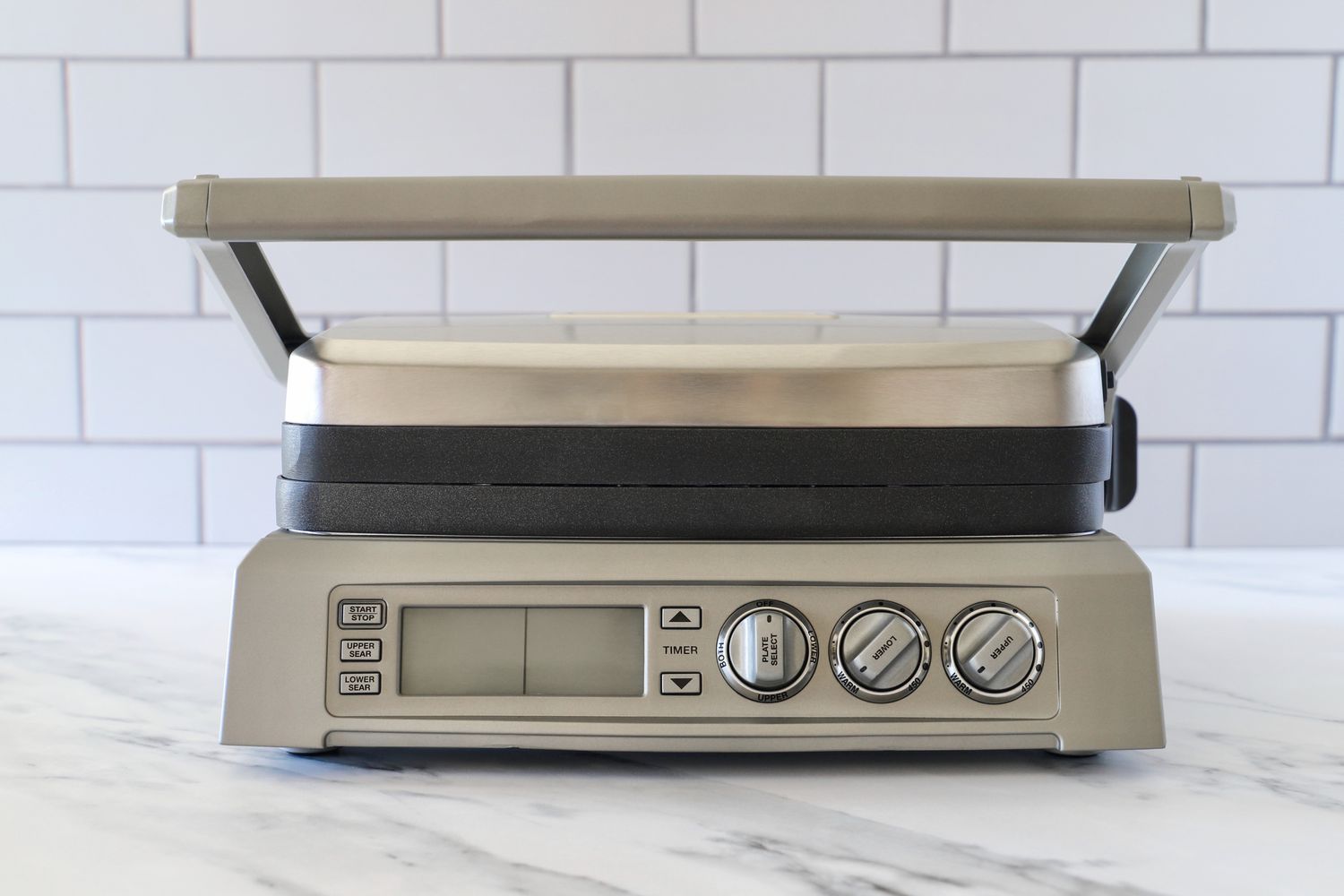 a panini press with its lid closed on a marble surface