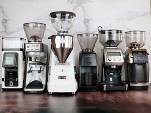 six espresso grinders lined up against a marble backdrop