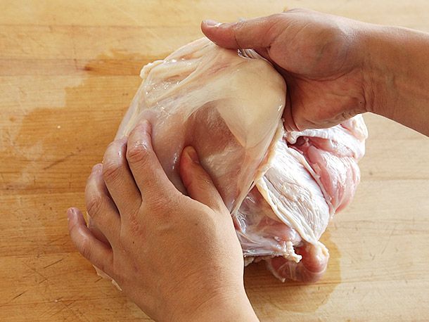 用两个手来用手臂，用火鸡手套把火鸡切成两半。