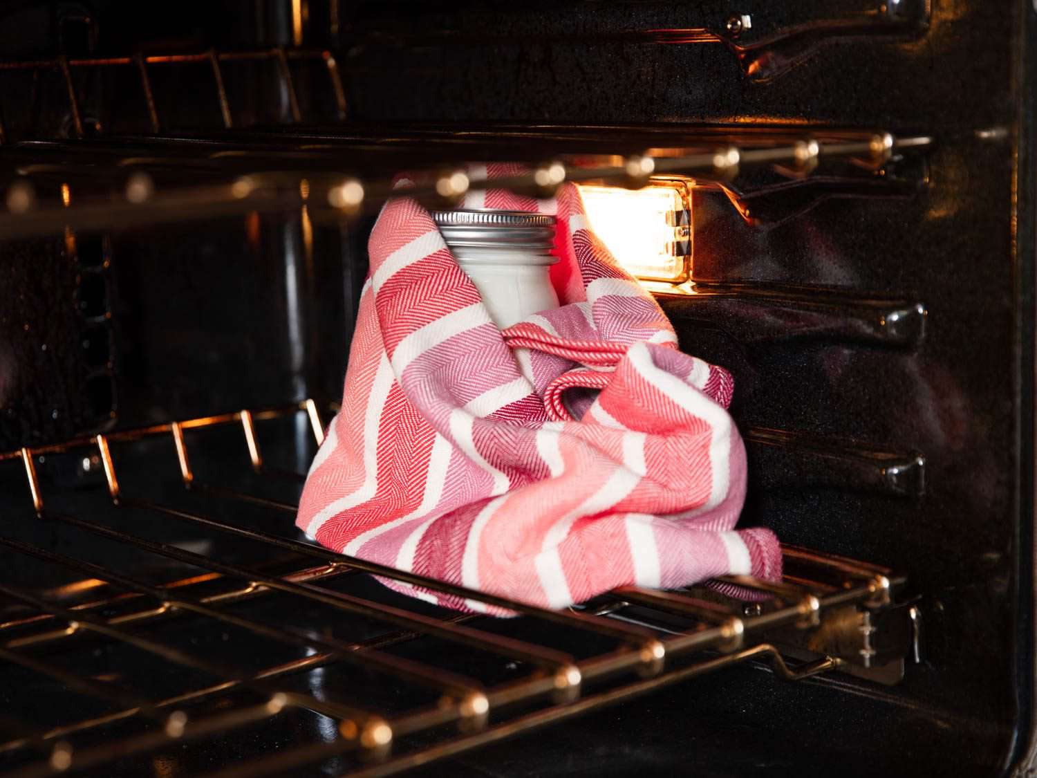 把酸奶包在毛巾里，把它放在一个关掉的烤箱里，开着灯，这样可以让酸奶保持足够的温暖。