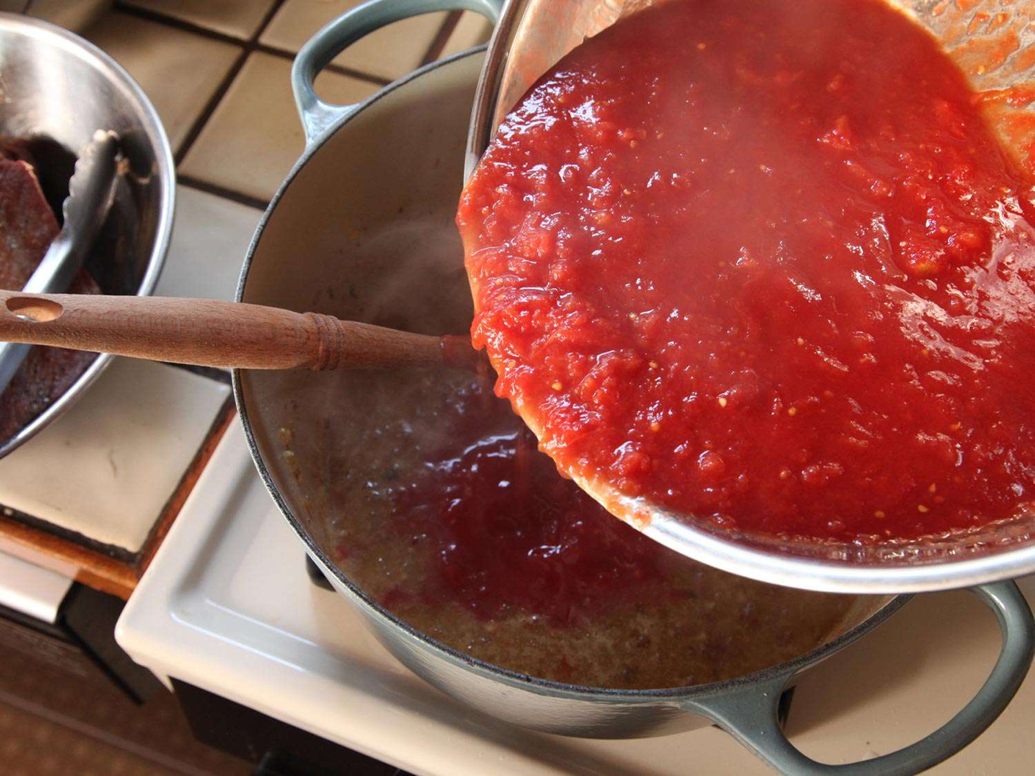 在荷兰烤箱中加入碎番茄。