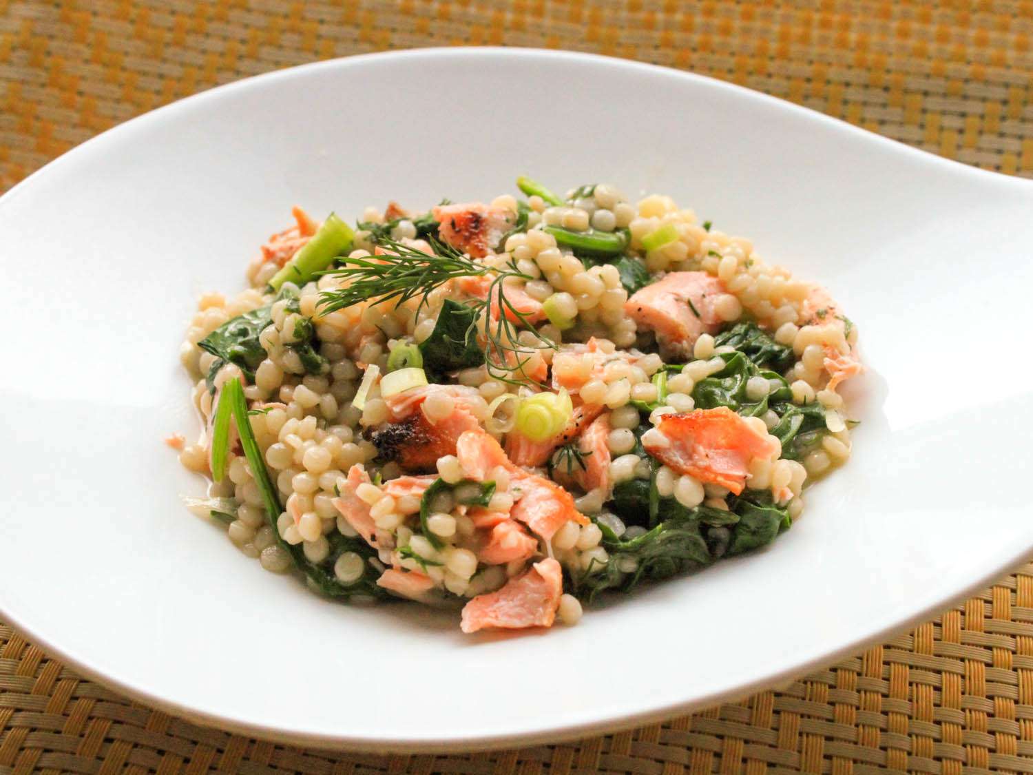 Finished couscous salad with salmon and dill on a plate.