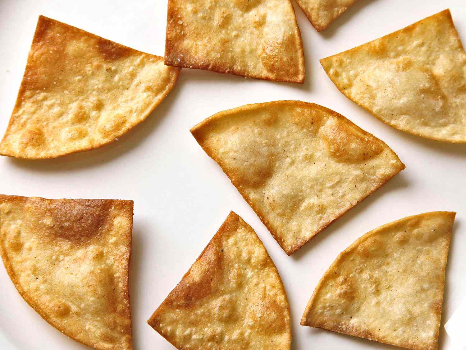 Overhead close-up of well-toasted tortilla chips.