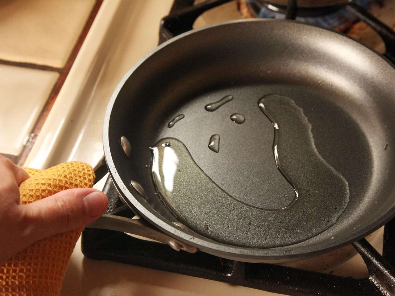 向不粘锅中加入油。