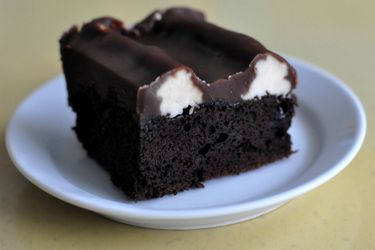 A slice of bumpy cake served on a small white plate. The bumps of vanilla buttercream are visible.