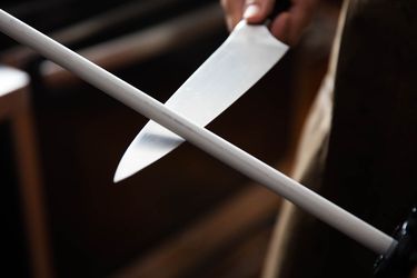 a knife being sharpened with a ceramic honing steel