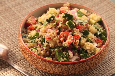 Bowl of quinoa salad with cucumber, tomato, and herbs