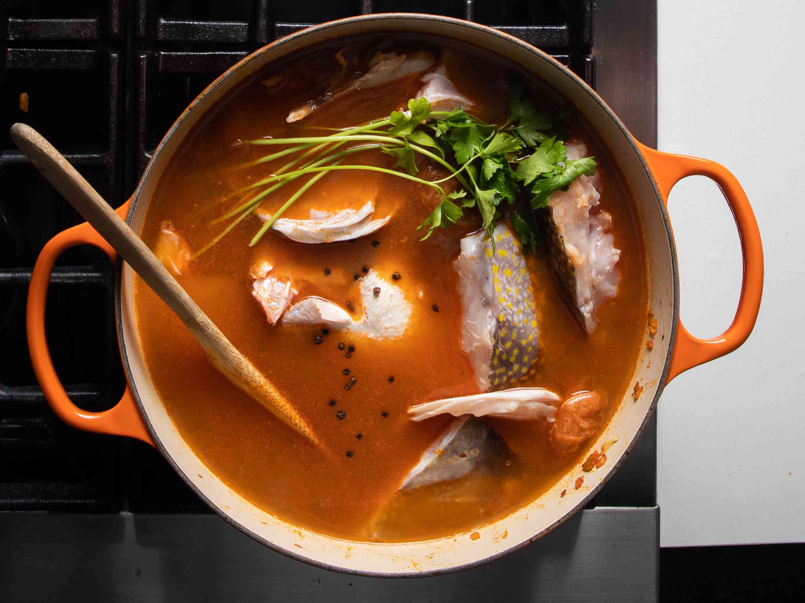 海鲜高汤完全装进锅里，包括鱼头、鱼骨和草药。