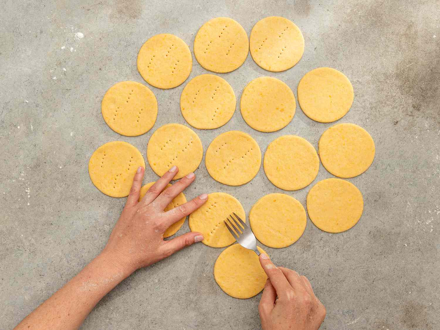 Overhead view of pricking dough with a fork