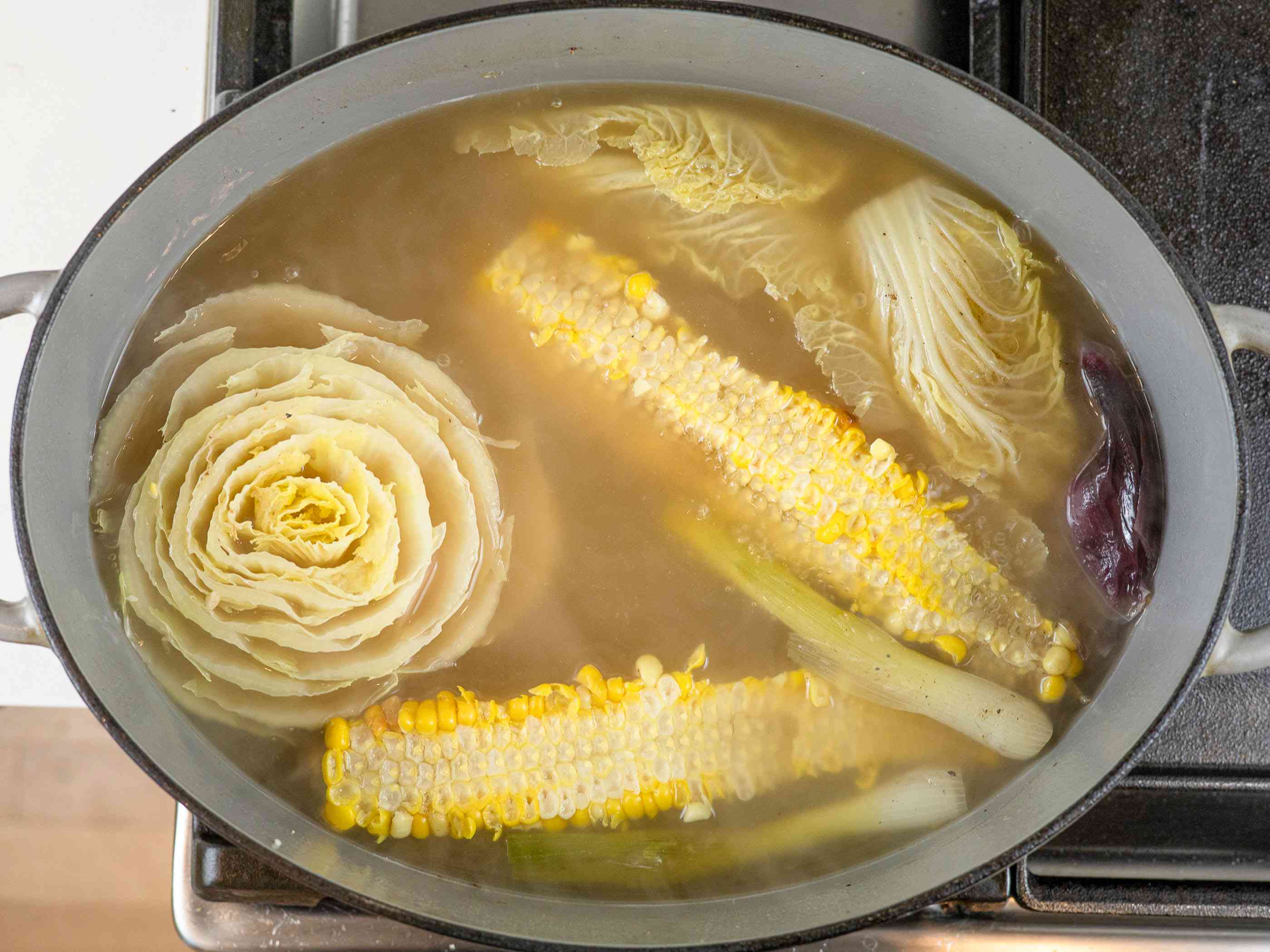 在荷兰式烤箱里，用水煨蔬菜、佐料和玉米芯
