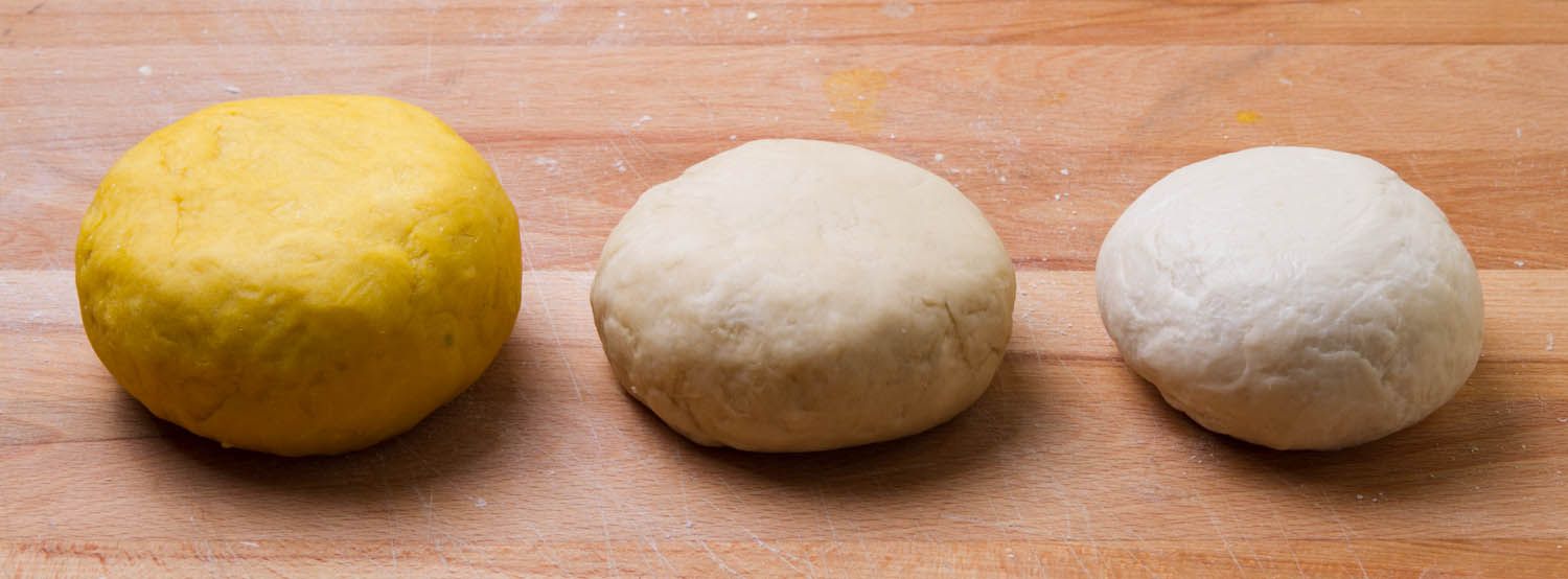 三个面团球，一个是蛋黄做的，一个是蛋白做的，还有一个是面粉和水做的。