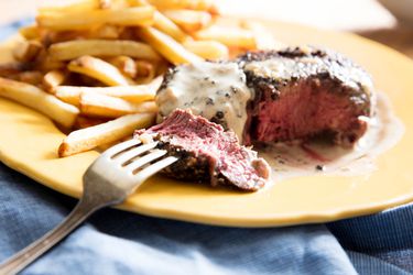 一个平台e of steak au poivre with french fries.