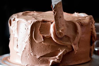 给蛋糕涂上巧克力瑞士奶油糖霜。