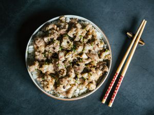 俯瞰蒸排骨上的一盘米饭，旁边放着一双筷子。