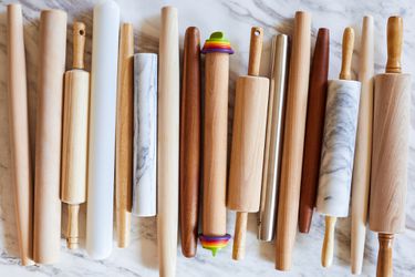 a group of rolling pins clustered together on a marble surface