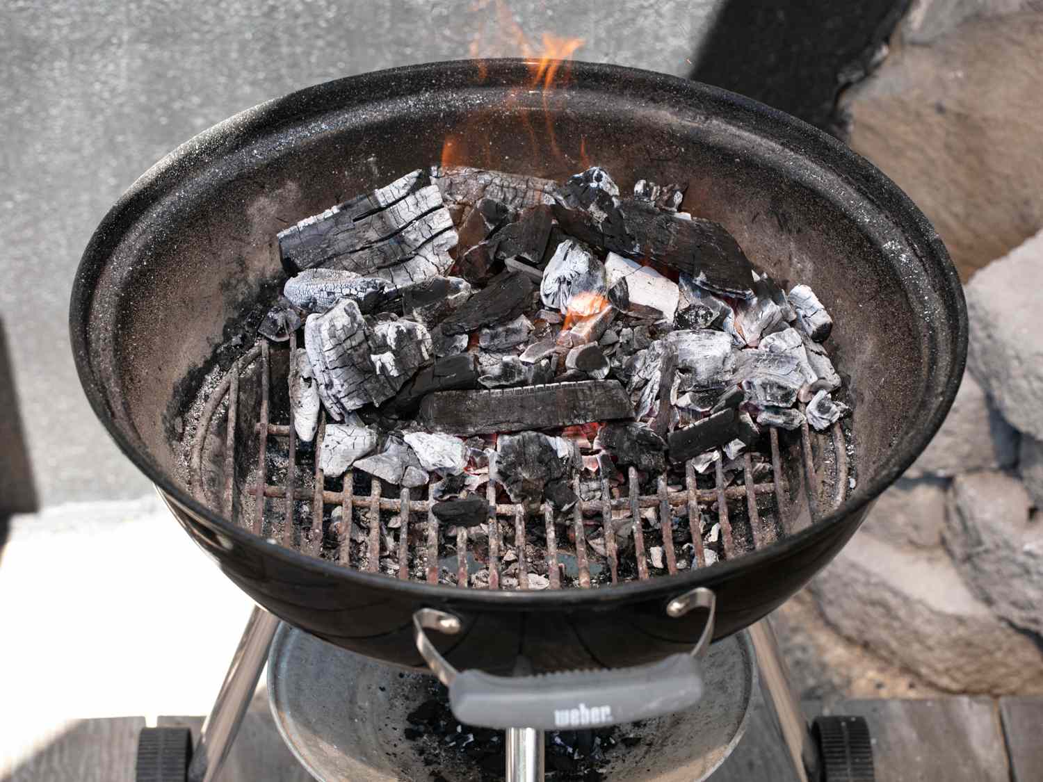 Charcoal added to kettle of grill for making elotes