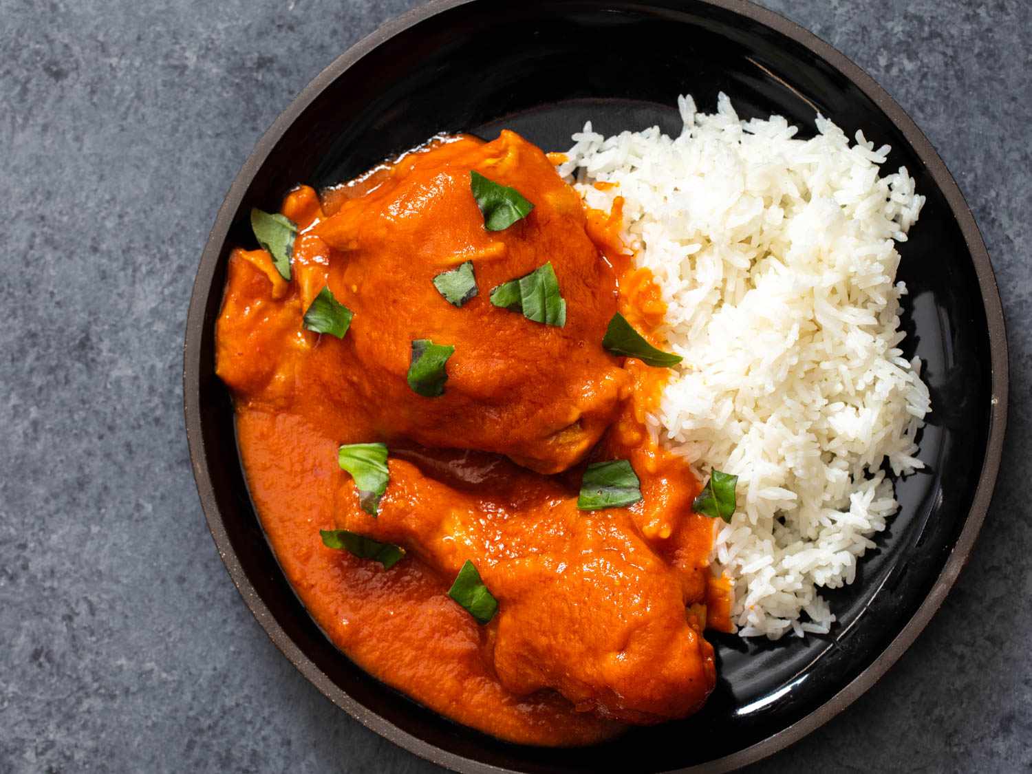 Top down view of a plate of rice served with chicken simmered in obe ata.