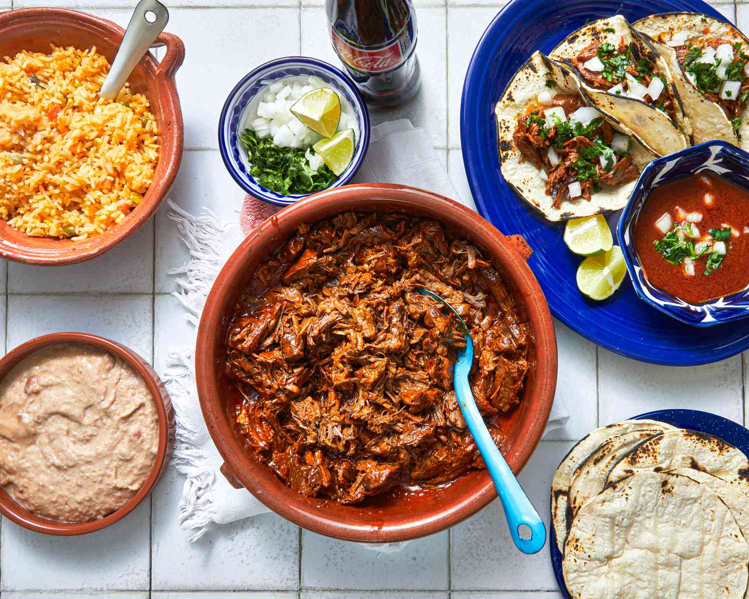 Overhead view of bowl of birria and assorted sides