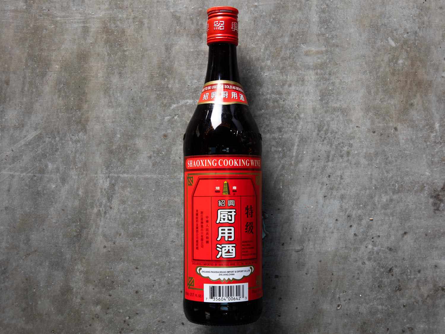一瓶黑色绍兴酒，灰色背景下有红色标签
