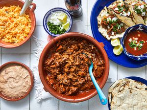Overhead view of bowl of birria and assorted sides
